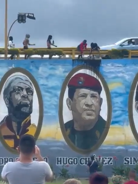 Venezolanos lanzan pintura negra a mural donde figura Hugo Chavez