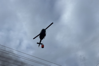 Helicóptero realiza descargas de agua para combatir incendio en L&R Comercial